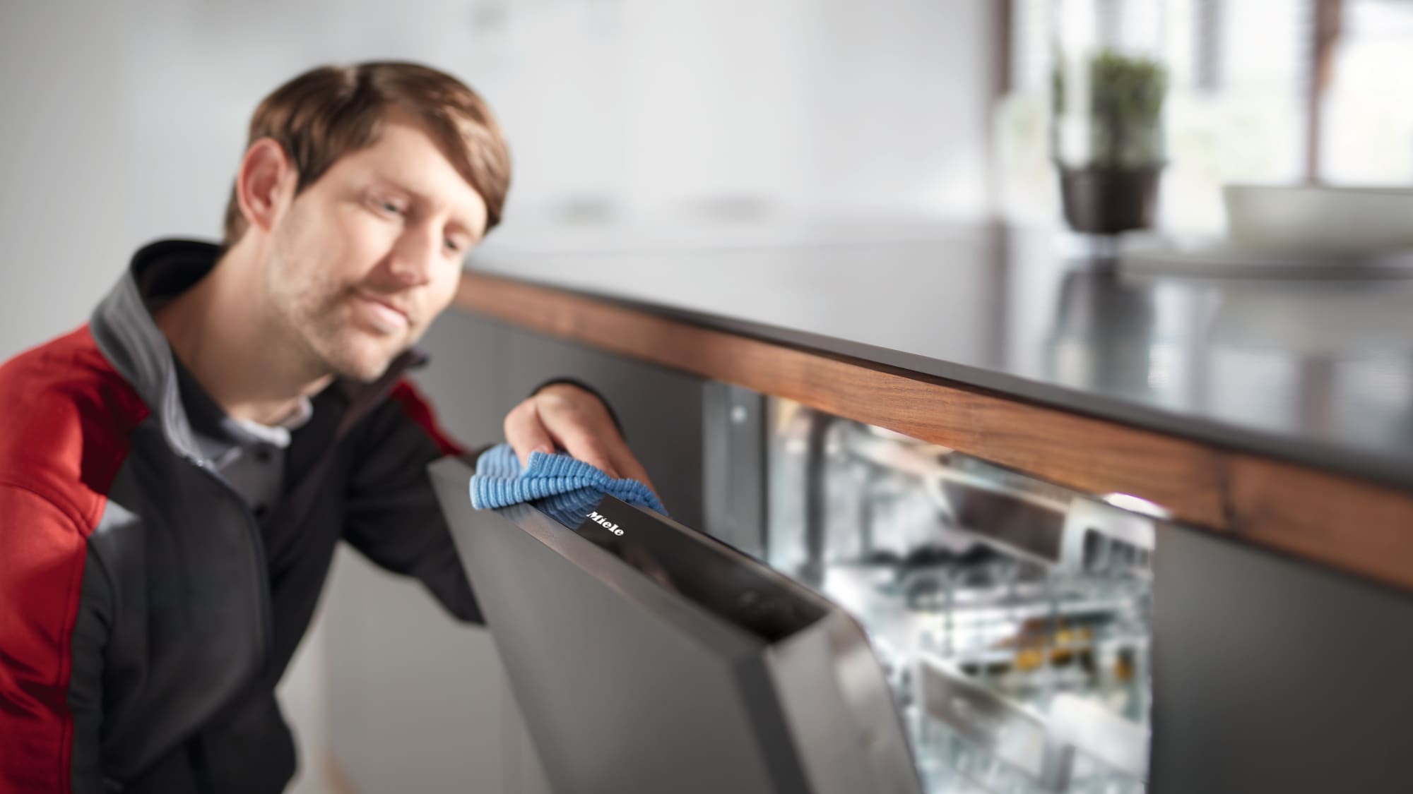 a Miele representative cleaning a Miele dishwasher